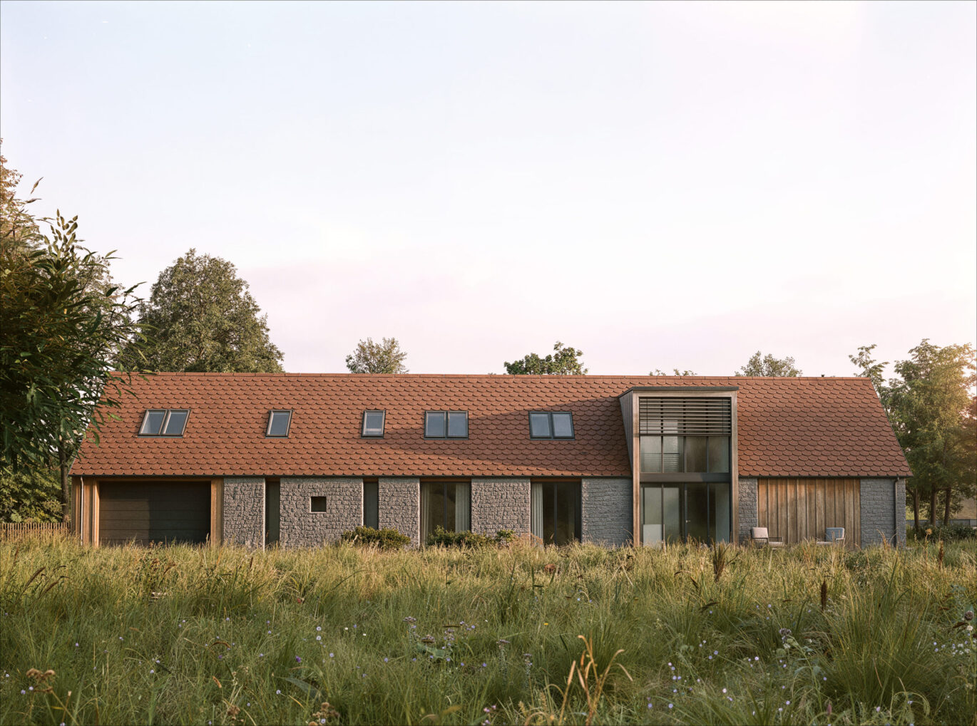 Podélná fasáda rekonstruované stodoly Tálín s kamenným zdivem, pálenou krytinou a střešními okny, návrh od architektů z MA Studia